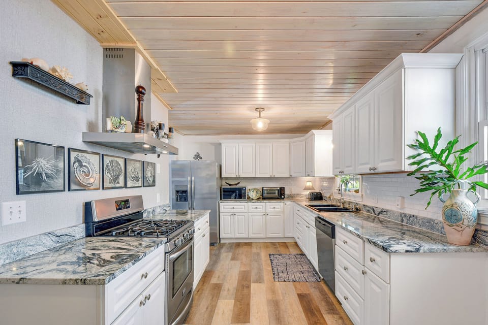 Kitchen with Gas Range and Long Counters - Galley kitchen has stainless appliances, gas range, granite counters, sink, dishwasher, and a long prep area.