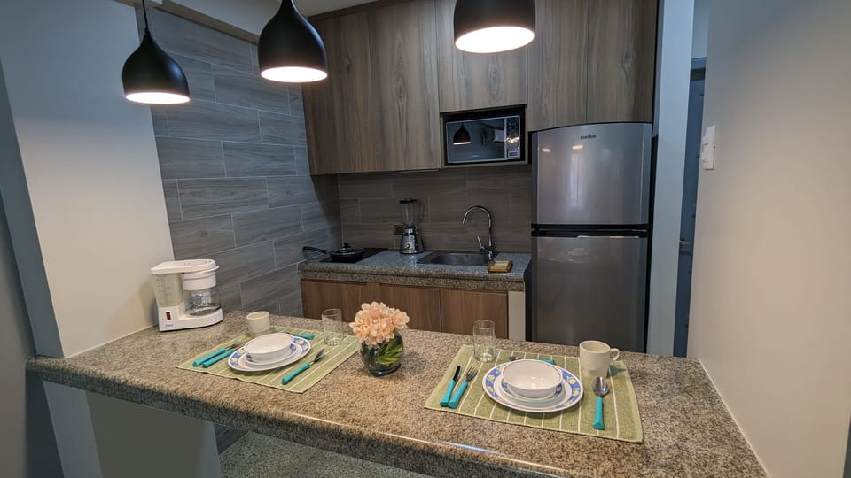 Kitchen view, including 2 burner stove, microwave, refrigerator  