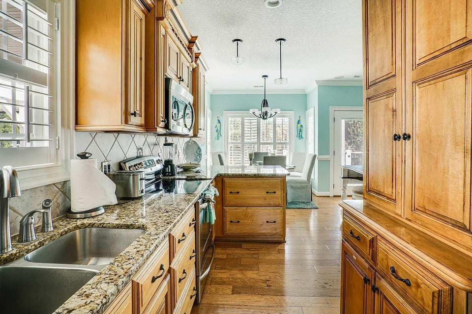 Sunlit kitchen with warm wood cabinetry and modern appliances