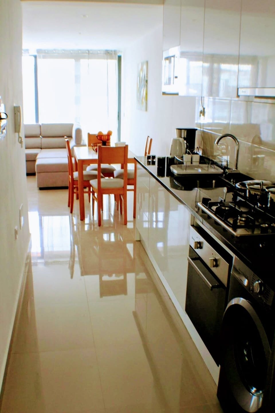 Full kitchen with gas stove and oven, refrigerator, pots, pans, dinnerware

