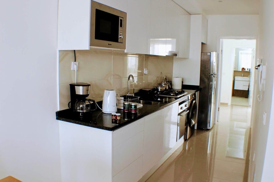 Full kitchen with gas stove and oven, refrigerator, pots, pans, dinnerware