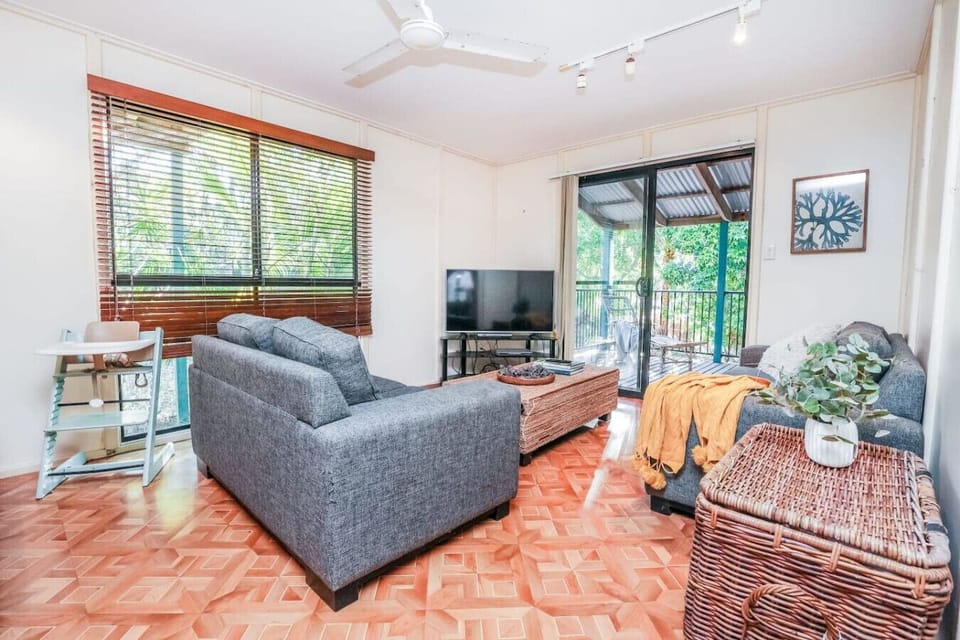 Lounge with sectional sofas, wicker coffee table, and coastal décor. Family‑friendly space with modern fittings and natural light.
