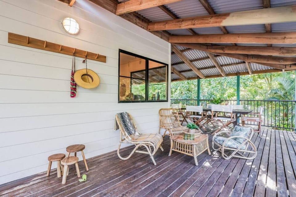 Outdoor patio with wicker lounge, dining area, and coastal décor. Family‑friendly space for outdoor dining and gatherings.