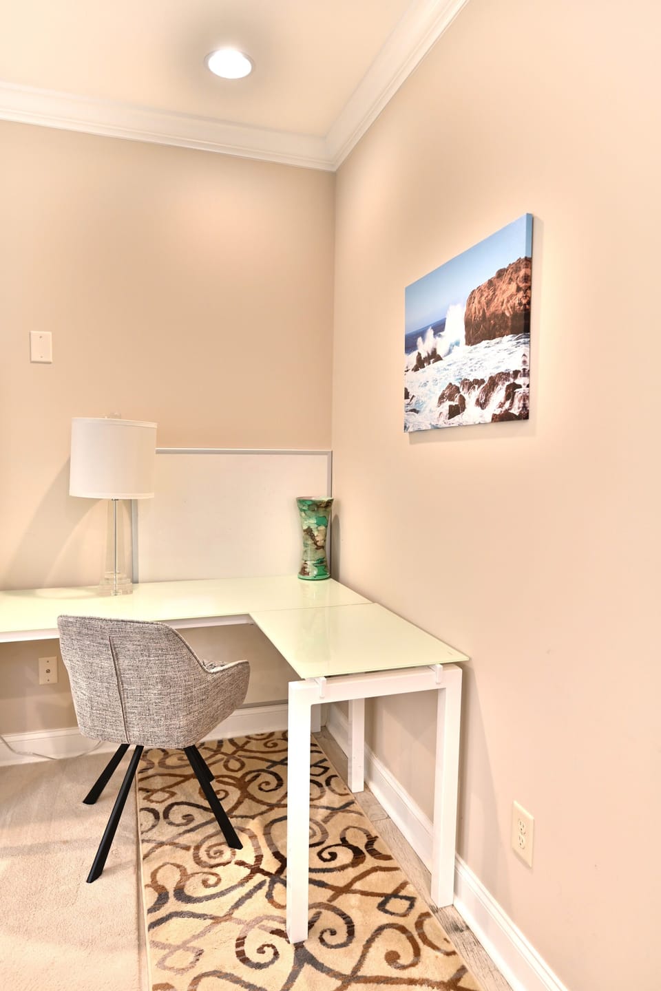 Minimalist workspace with white desk, gray chair & stylish rug.