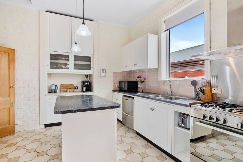 Cook up a storm in the fully equipped, modern kitchen featuring sleek countertops and appliances, including a stainless steel gas stove and dual-drawer dishwasher.