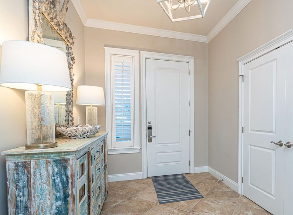 Step into your elegant entryway with coastal charm—distressed blue console, warm lighting, and sophisticated touches welcome you home.