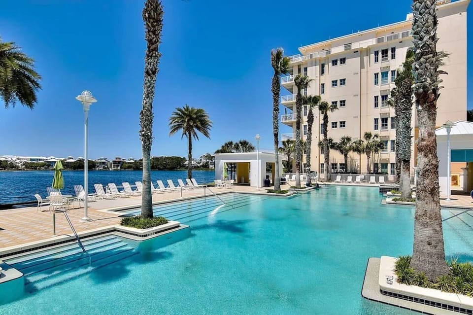 Resort-style pool with sparkling waters and palm-lined waterfront setting creating a tropical paradise atmosphere.