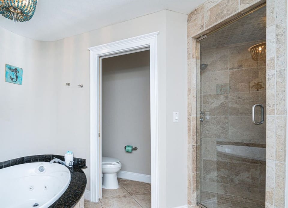 Unwind in your spa-inspired bathroom with a tub and spacious stone shower for the ultimate relaxation experience. - Please note the jacuzzi feature is out of order but the tub is still usable