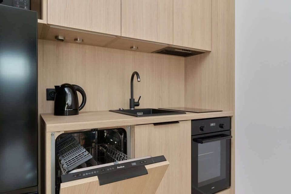 Kitchenette with wooden shelving, coffee maker, and compact appliances.
