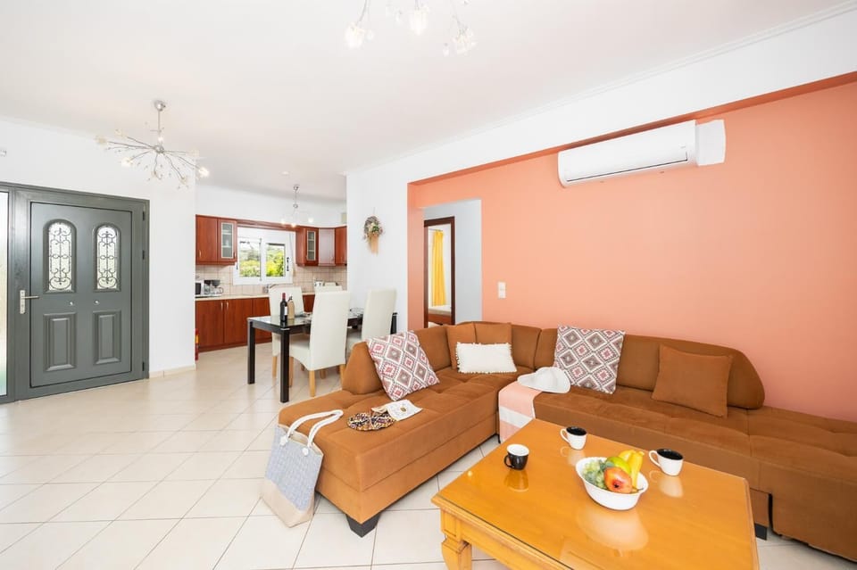 Open-plan living room with sofa, dining area, kitchen, A/C, WiFi internet, and satellite TV