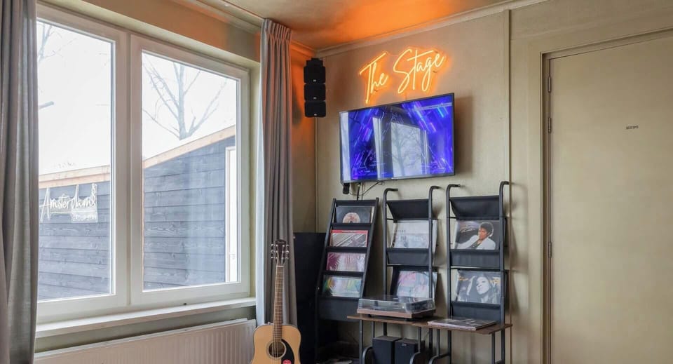 The Music Corner – The Stage features a professional sound system, compatible with your own DJ set or ours, a Sunvig Karaoke Box, record player with vinyl, guitar, Smart TV, and immersive audio for unforgettable nights together.