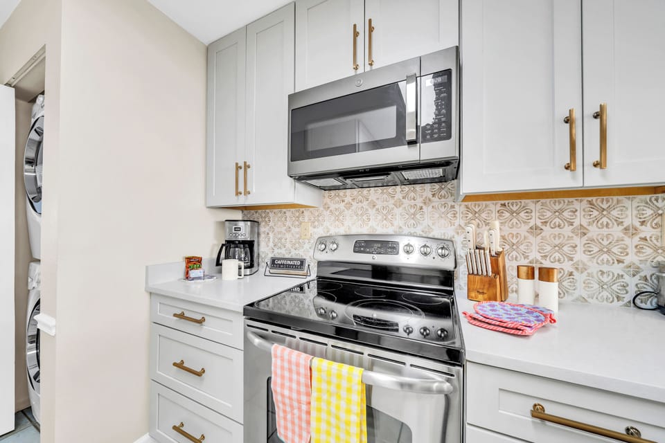 Your fully equipped kitchen awaits with modern appliances and charming tile backsplash, perfect for preparing meals during your stay.
