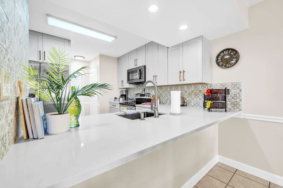 Cook your favorite meals in this bright, modern kitchen with sleek countertops, premium appliances, and charming decorative touches.