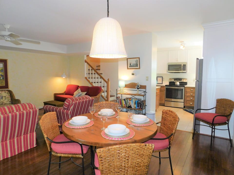 Dining & Social Area - Demonstrates the unit's capacity for hosting. The dining area is positioned to take advantage of the natural light flowing from the rear sliding doors, which lead to the screened-in porch.