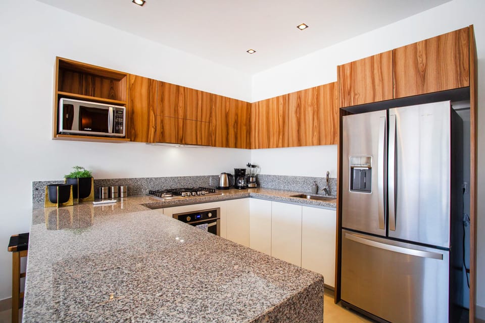 Fully-equipped kitchen with high-end amenities like fridge, stove, oven and microwave