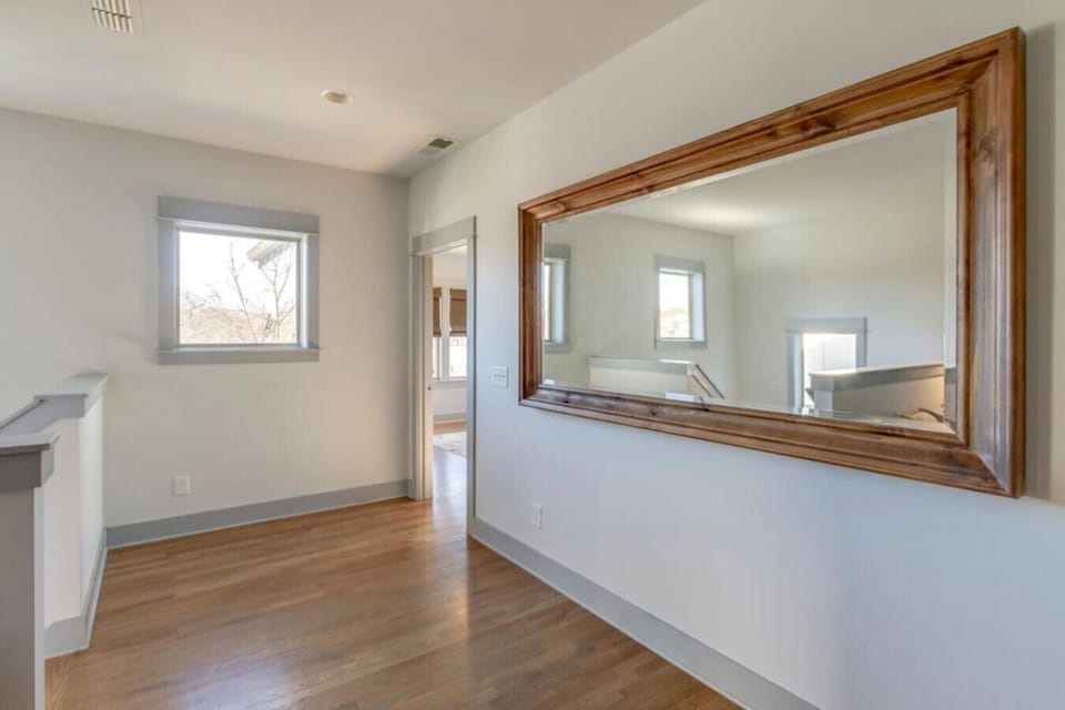 A bedroom with a dresser and mirror shows the full storage and styling of the room.