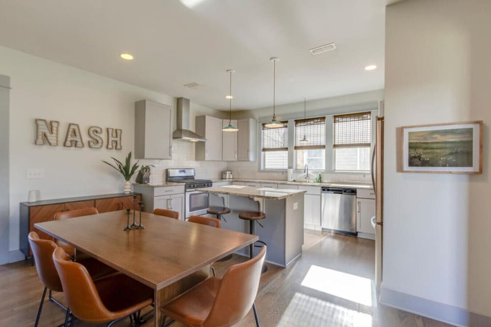 The kitchen features a bold NASH sign, open shelving, and a dining island with a warm, modern feel.