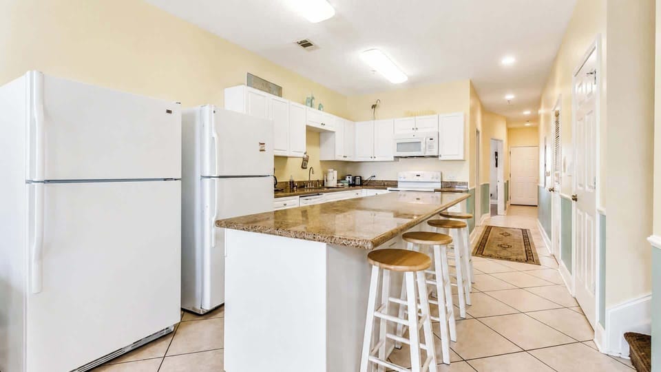 Full kitchen with granite counters, a breakfast bar, and two full-size refrigerators for group meals.