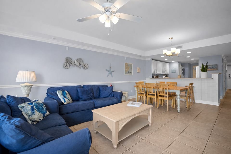 Living room open to kitchen and dining area.  Couch, loveseat and bench seating