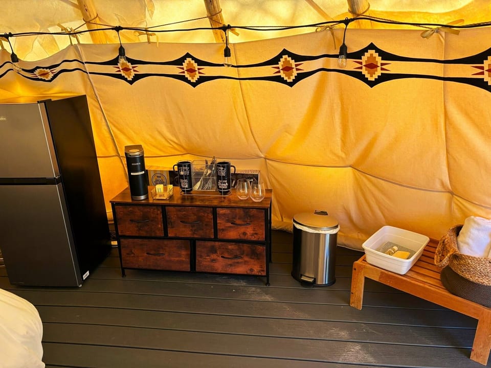 Fresh towels, trash can, small chest of drawers, cups, dishes, bowls, and flatware. 