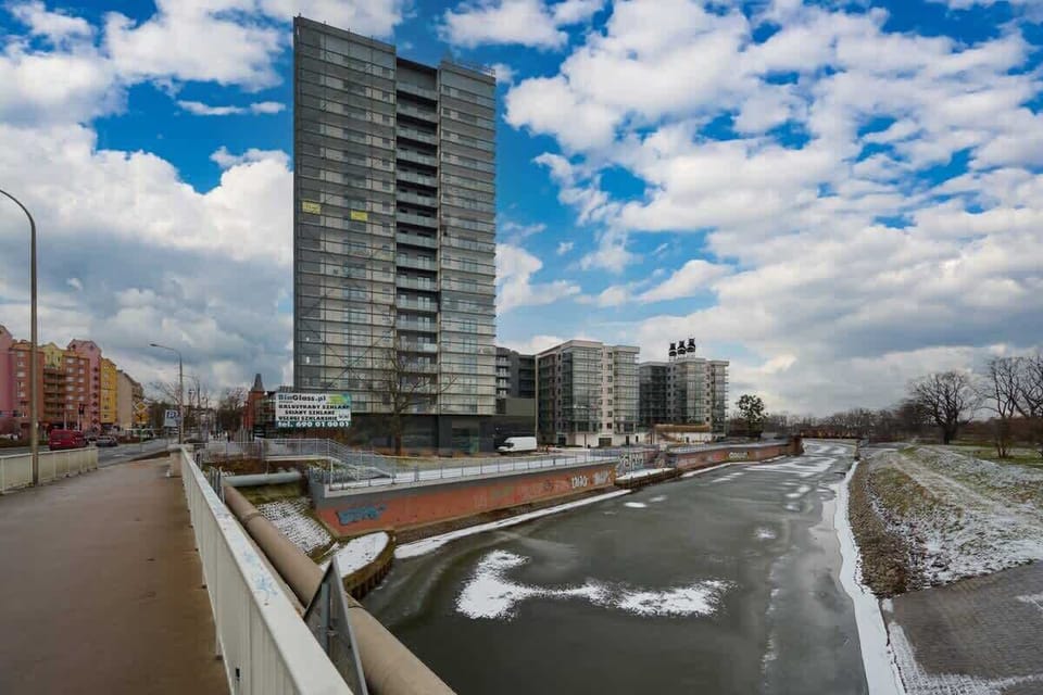 Scenic river view with modern high-rise buildings and winter landscape.
