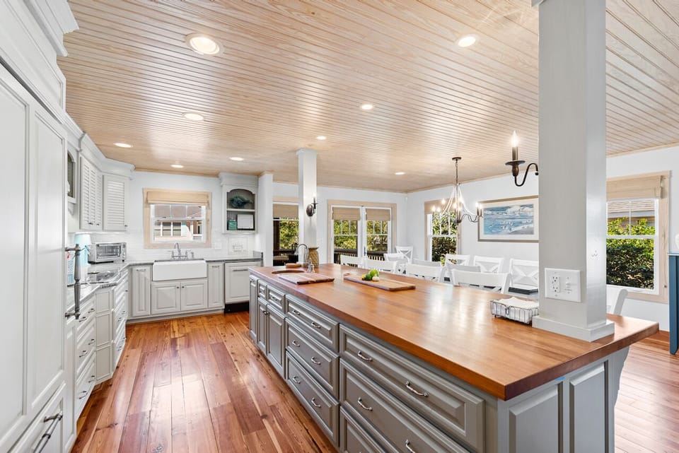 Your spacious gourmet kitchen invites culinary adventures with its expansive island, gleaming countertops, and abundant natural light streaming through charming windows.