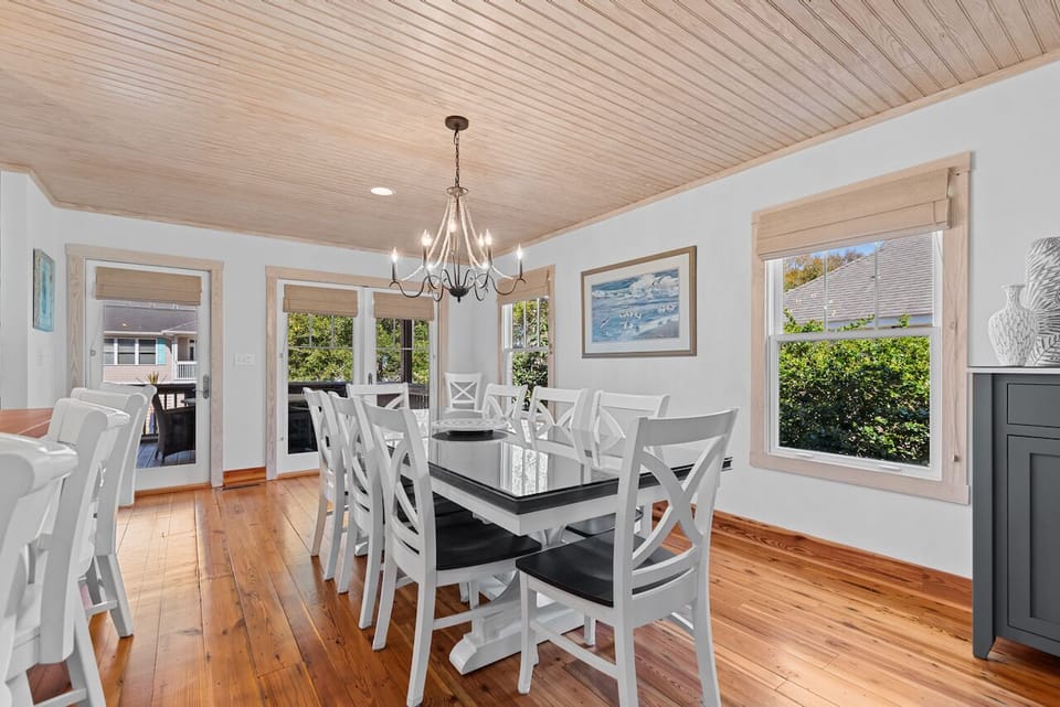 Gather around this elegant dining table where warm wood floors and a charming chandelier create the perfect setting for memorable meals together.