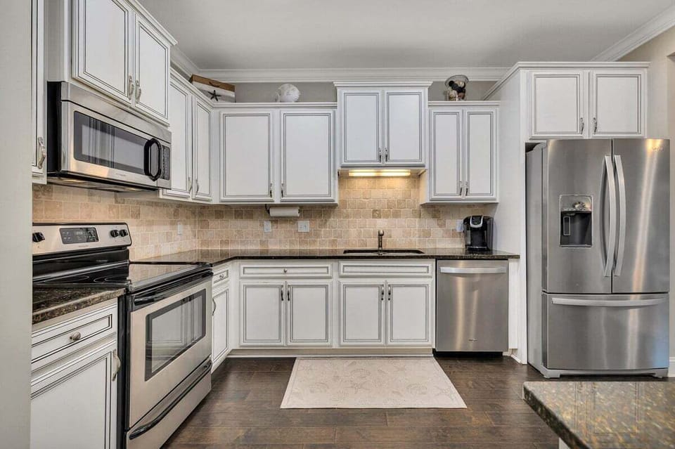 White kitchen with stainless range and refrigerator