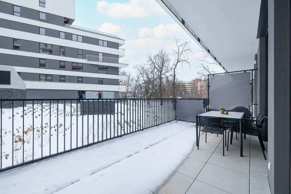 Second balcony view with snow-covered landscape and modern facade.
