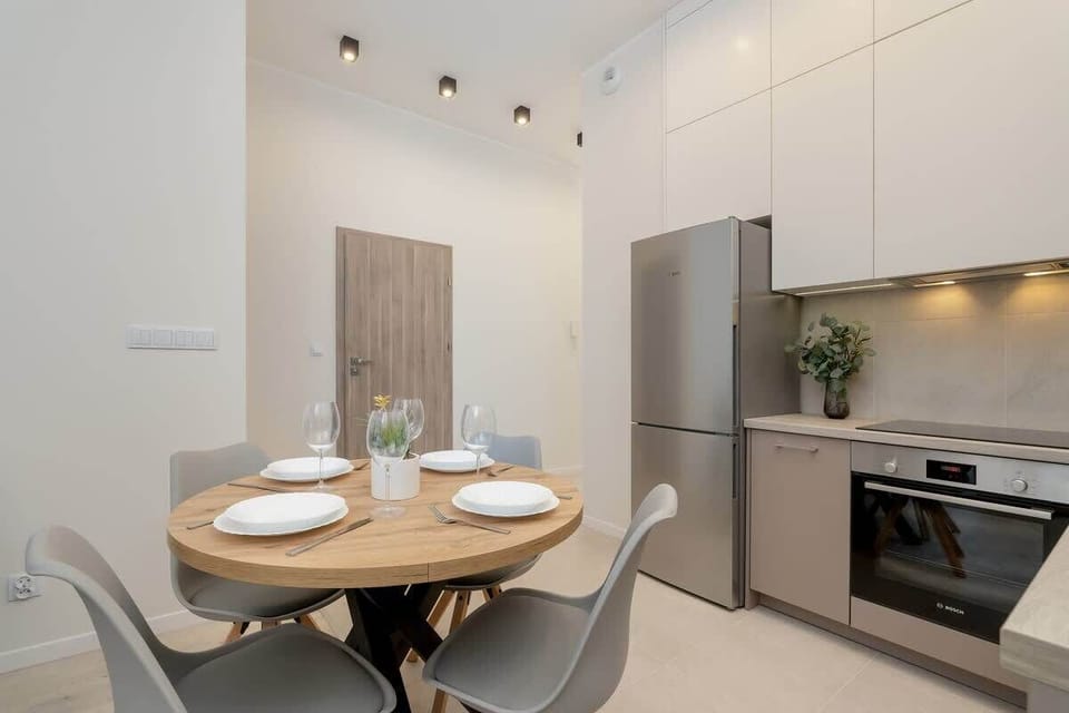 Dining area set for four with wooden table and gray chairs.
