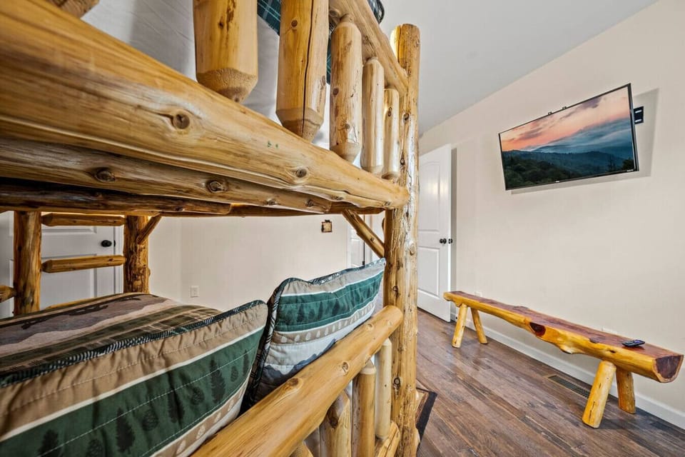 The bedroom includes a separate bench and large Smart TV.