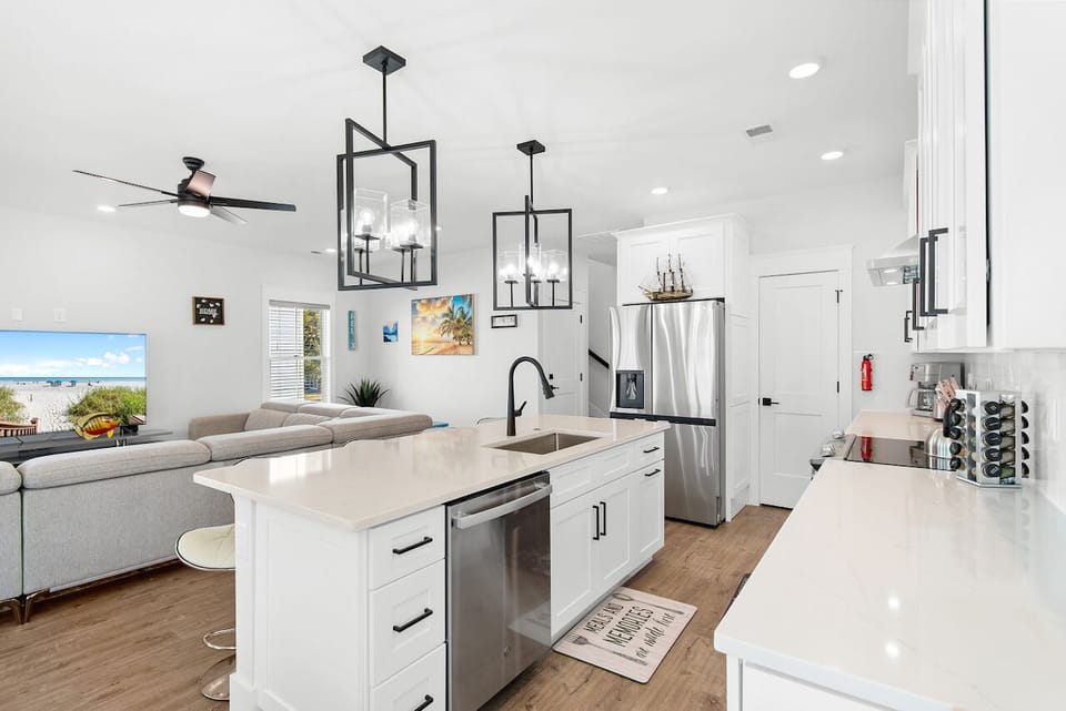 Your sleek, modern kitchen features pristine white countertops and stainless steel appliances, perfect for preparing meals while gazing at the ocean view.