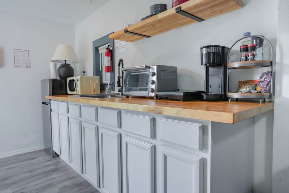Clean and functional kitchen area with modern appliances and open shelving, making it easy to prepare simple meals during your stay