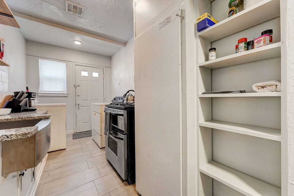 Cozy kitchen with built-in pantry shelves and a farmhouse sink, offering both charm and practical storage.