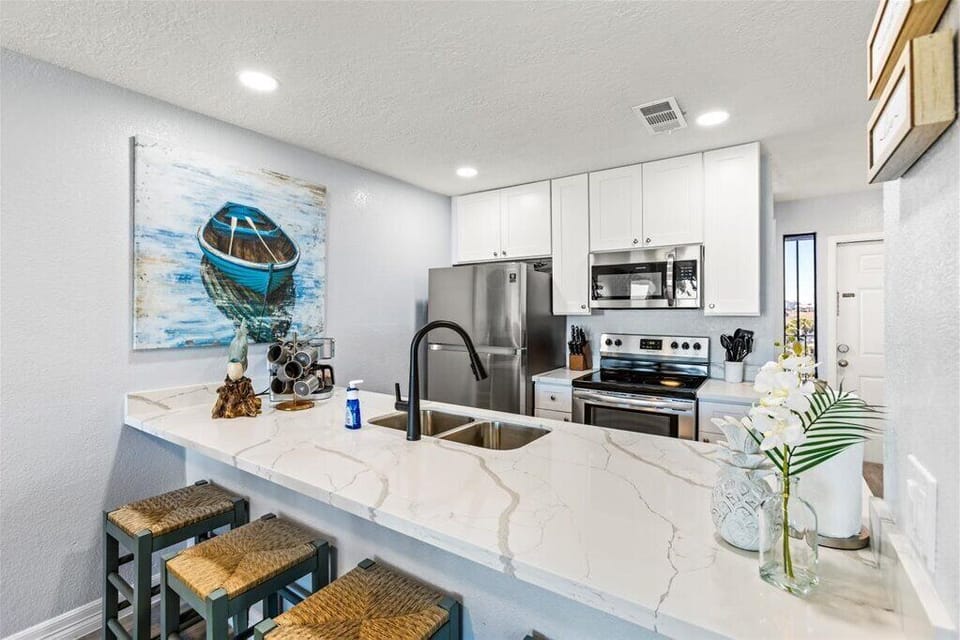 Bright, modern kitchen with marble counters and beachy decor for fun cooking!