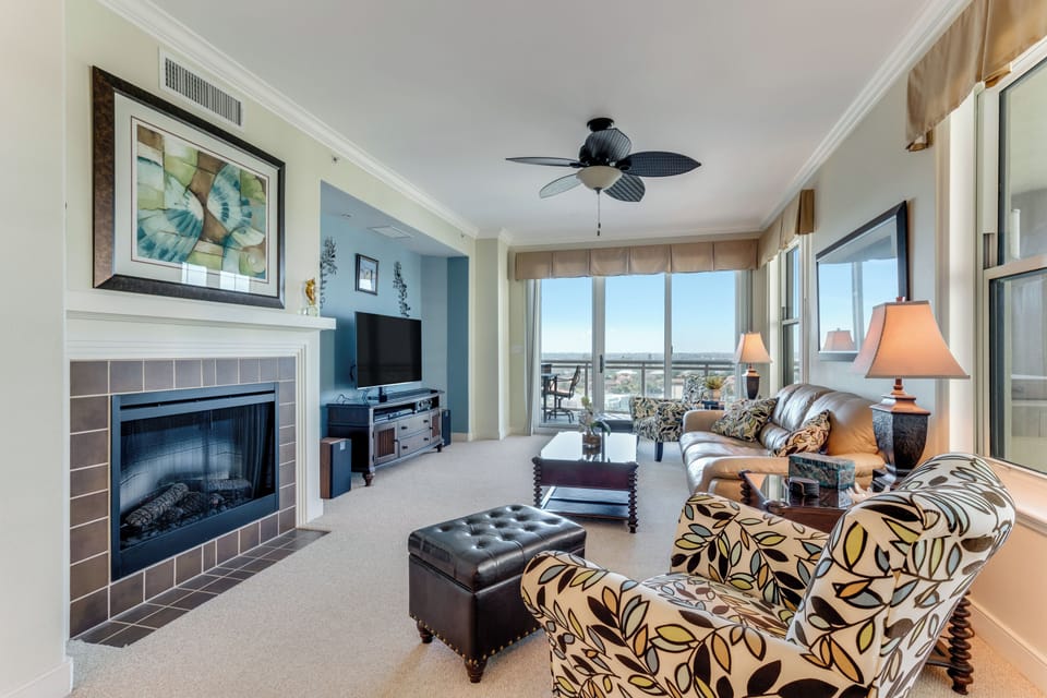Large living room with queen sleeper sofa, electric fireplace & balcony access