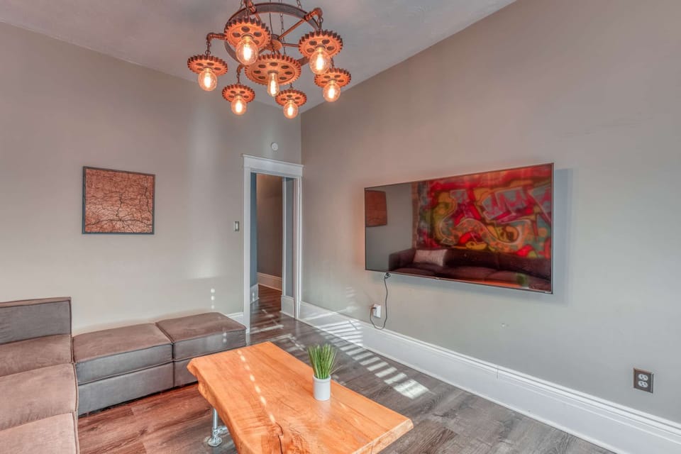 Stylish lounge area w/ sectional seating, wall-mounted TV &amp; bold artwork for relaxing indoors