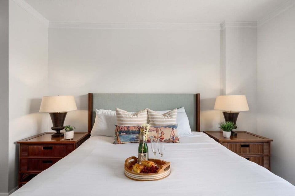 Comfortable bed with decorative pillows and bedside lamps