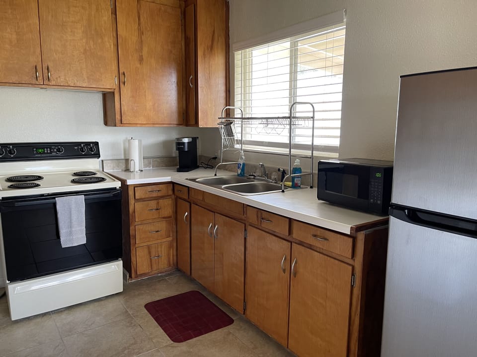 Kitchen sink and stove, equipped for preparing delicious meals.