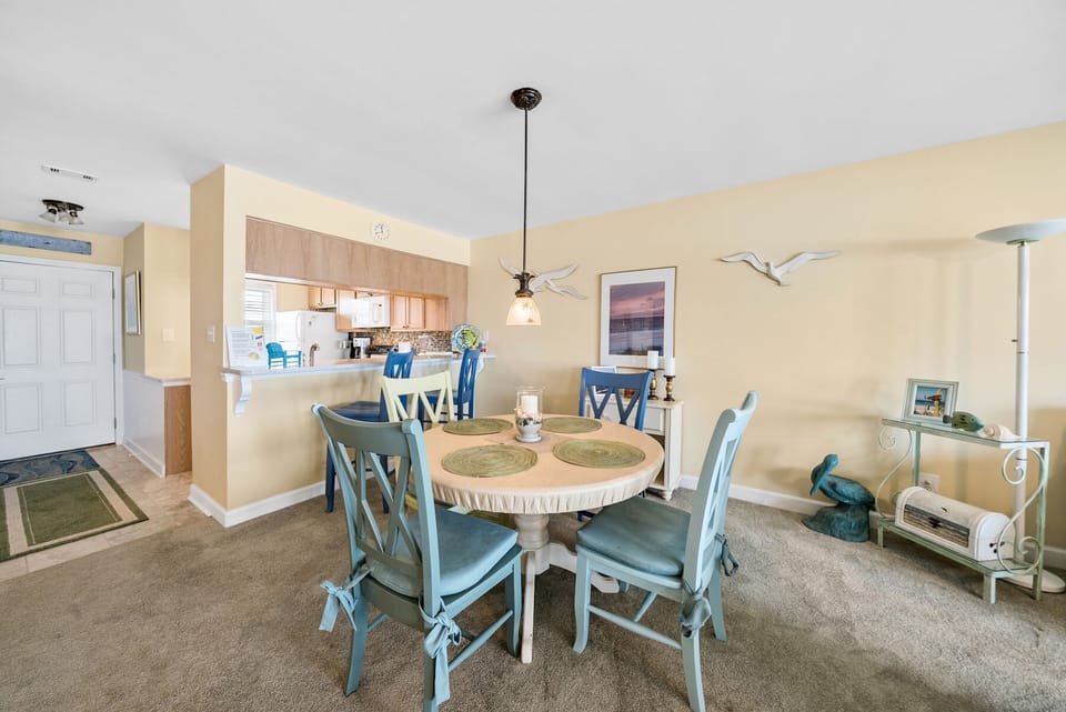 Your bright dining space features coastal-inspired seating and flows seamlessly into the fully equipped kitchen, perfect for memorable meals together.