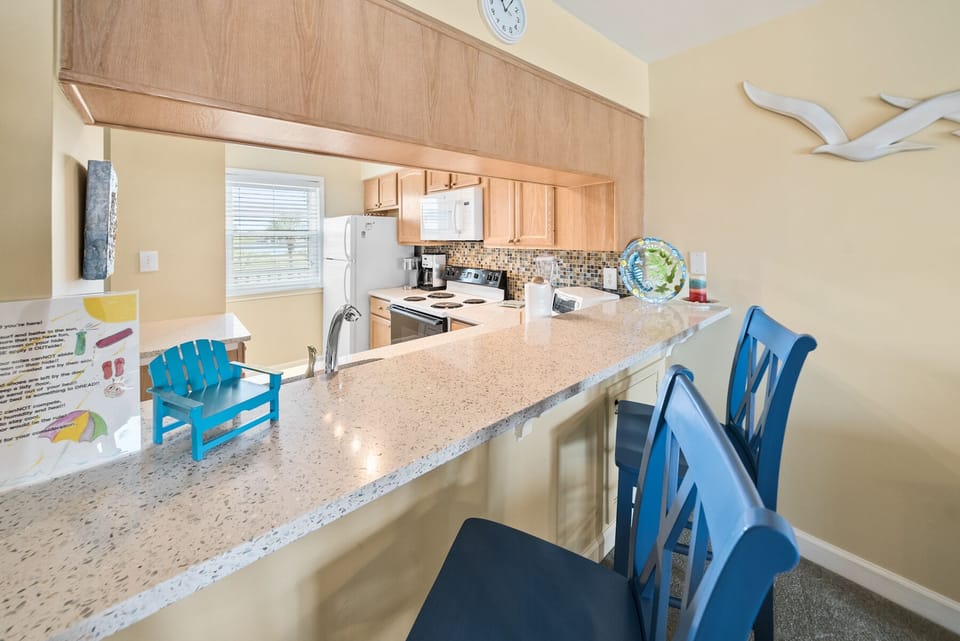 Your fully equipped kitchen features granite countertops, modern appliances, and a breakfast bar perfect for morning coffee or casual dining.