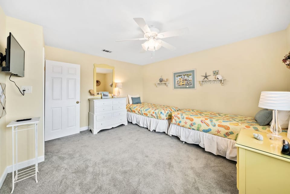 Relax in your cheerful twin bedroom with coastal décor, ceiling fan, flat-screen TV, and plenty of storage space for your belongings.