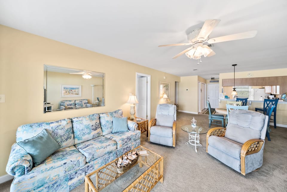 Relax in your spacious living room with coastal-inspired furnishings and gentle ceiling fan breeze flowing throughout your open-concept getaway.