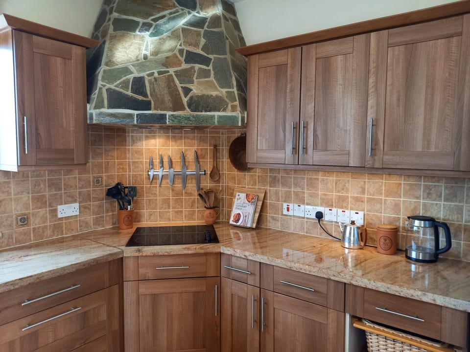 Kitchen view showing ceramic hob and stylish slate cooker hood