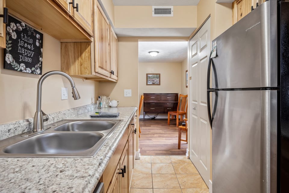 Bright galley kitchen w/ double sink, ample counter space & plenty of cabinet storage.