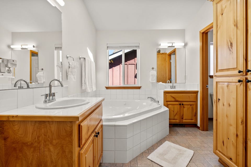 Bright spa-like bathroom with soaking tub and dual vanities