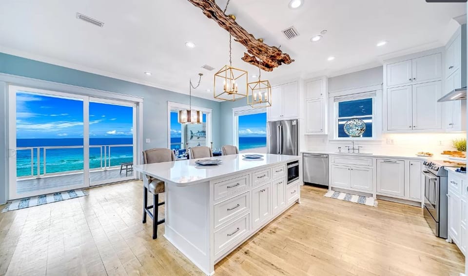 Your dream kitchen awaits with stunning ocean views, sleek white cabinetry, and modern appliances where you'll create memorable meals.