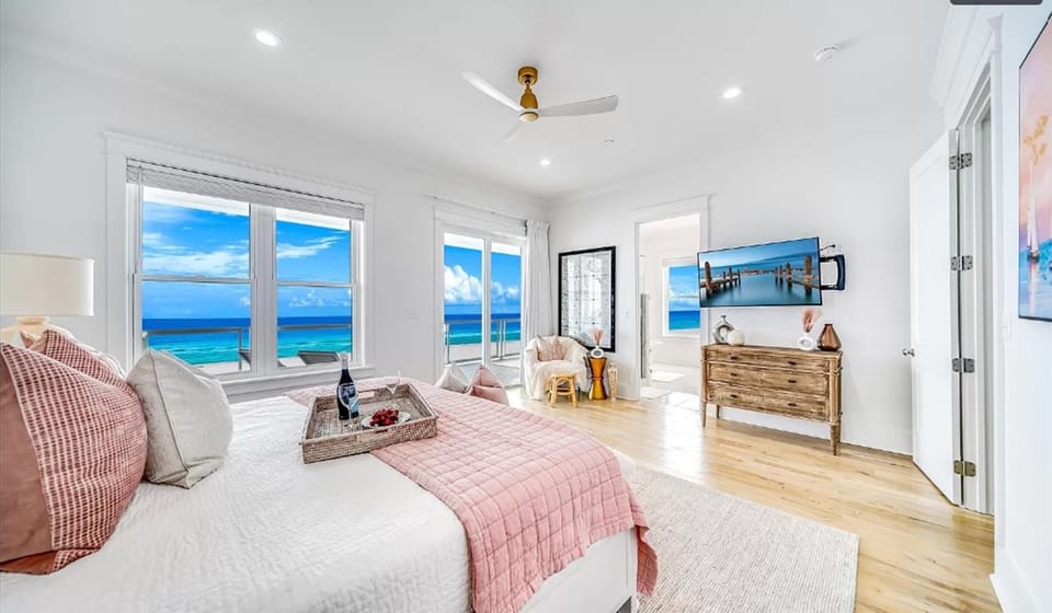 Wake up to stunning ocean views in your bright, airy bedroom where turquoise waters stretch endlessly beyond expansive windows.