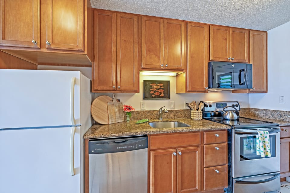 Kitchen with dishwasher, oven, stove, microwave, and refrigerato - Prepare Snacks, Meals, and Tropical Drinks with Ease