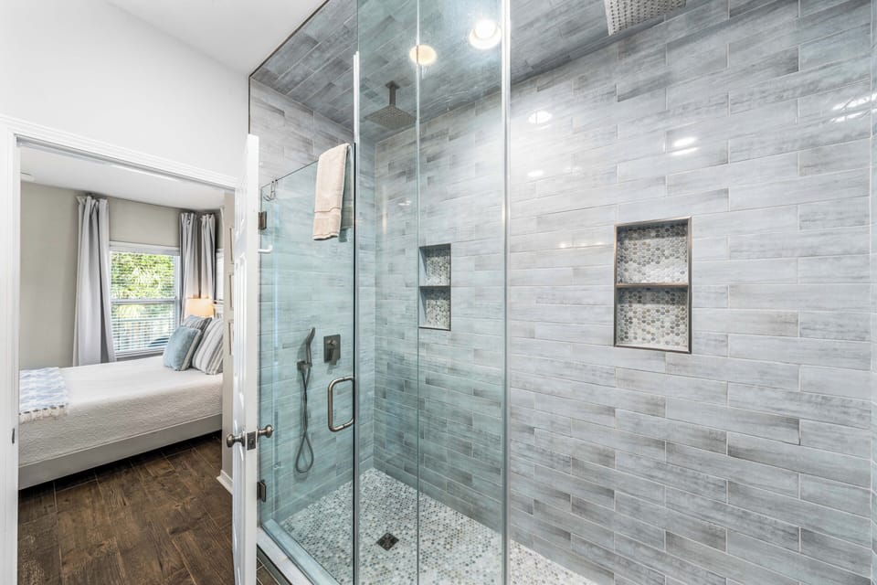The master bathroom features a walk-in shower with dual rain heads and wands. 
